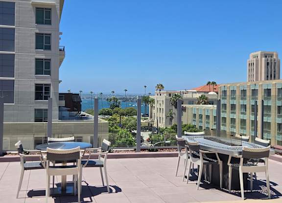 A patio with a table and chairs overlooks a cityscape.