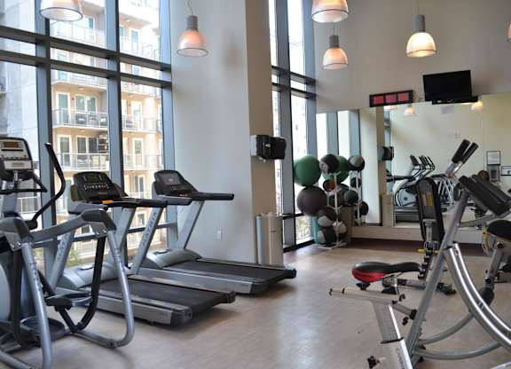 A gym with treadmills, elliptical machines, and other exercise equipment.