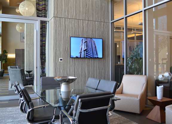 A modern living room with a television mounted on the wall and a chair set in front of it.