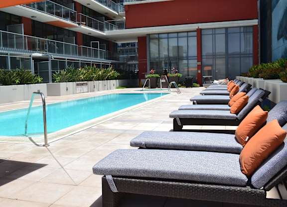 A pool with a slide and sun loungers.