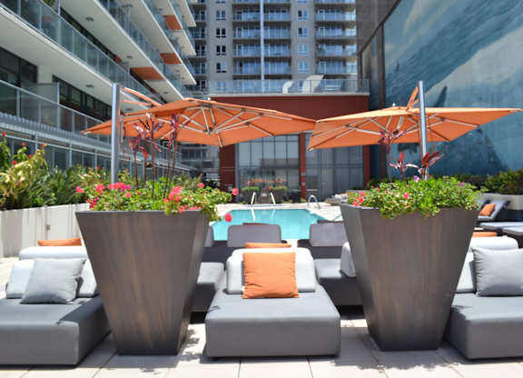 A pool area with lounge chairs and umbrellas.