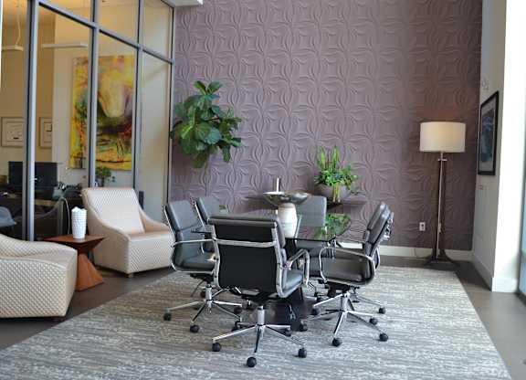 A conference room with a purple patterned wall and a grey carpet.