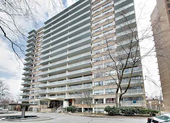 A tall residential building with a pool in front.
