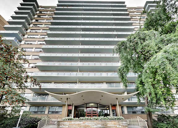 A modern building with a curved entrance and balconies on the upper floors.