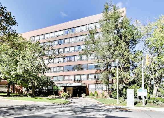 A large building with a lot of windows and trees in front.