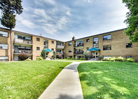 A grassy area in front of apartment buildings.