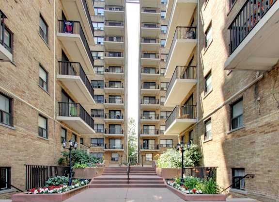 a view of a courtyard between two tall apartment buildings