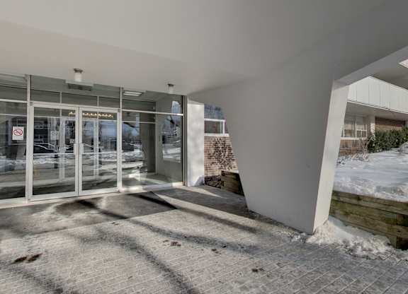 the entrance of a building with glass doors and a sidewalk