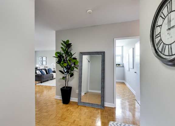 a living room with a large clock on the wall and a mirror