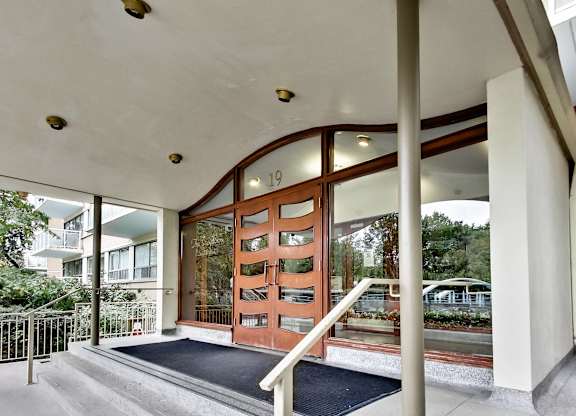 A building entrance with a black mat on the steps.