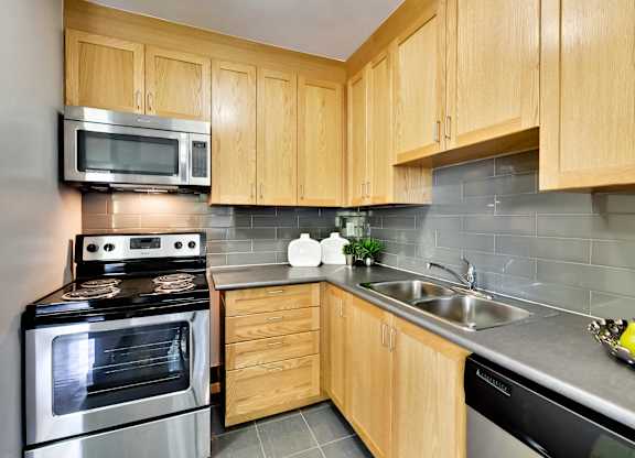 a kitchen with stainless steel appliances and wooden cabinets