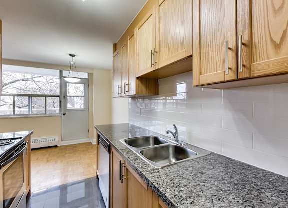 A kitchen with wooden cabinets and a granite countertop.