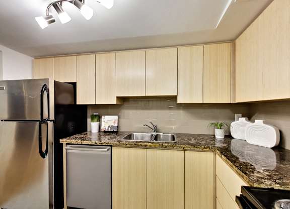 A kitchen with wooden cabinets and a granite countertop.