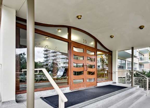 The entrance to a building with a black mat in front.