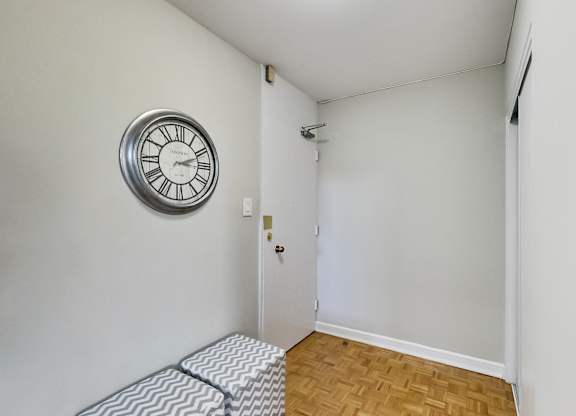 a living room with a clock on the wall and a couch