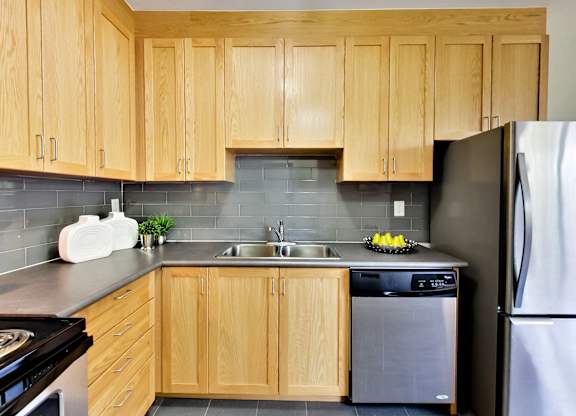 a kitchen with wooden cabinets and stainless steel appliances