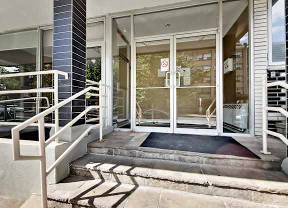 the entrance to a building with glass doors and stairs