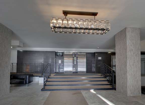 a lobby with a staircase and a large chandelier