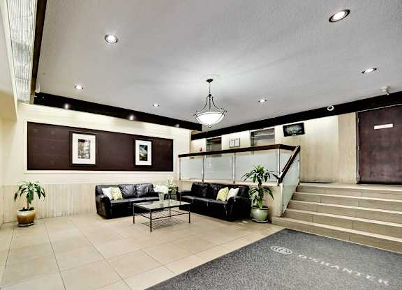 A living room with a couch, a coffee table, and a staircase.