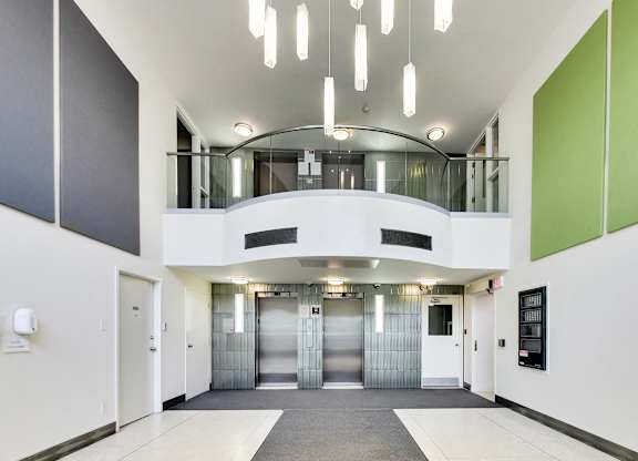 A hallway with a white floor, white walls, and a green accent wall.