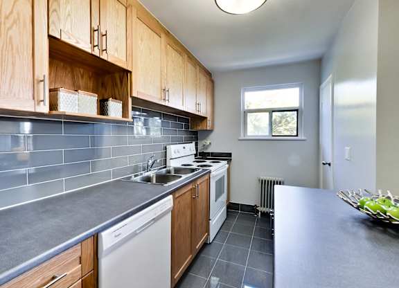 A kitchen with wooden cabinets and a white dishwasher.