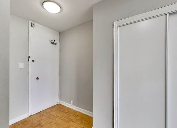a bedroom with a door to a closet and a wood floor
