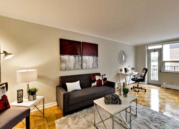 a living room with a couch and a chair and a desk