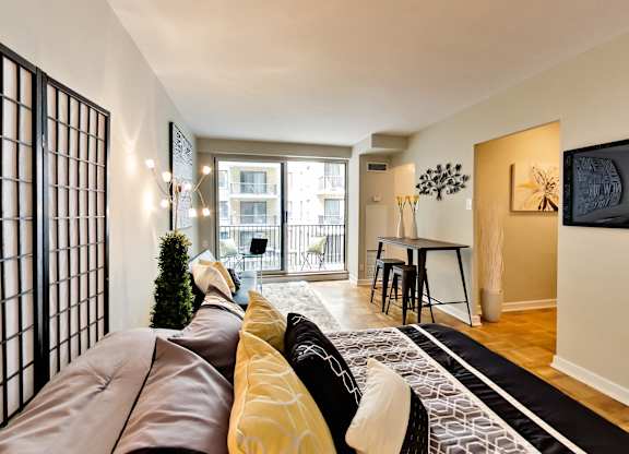 a living room with a couch and a tv and a dining room and a balcony