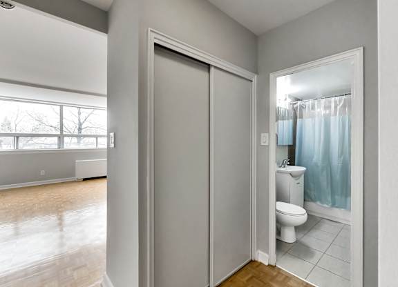 an empty room with a door to a bathroom and a toilet