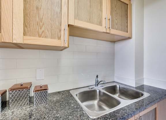 A kitchen with a sink and wooden cabinets.