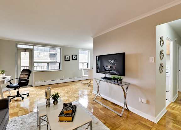a living room with a tv and a table with a chair