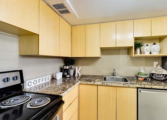 A kitchen with wooden cabinets and a black stove top.