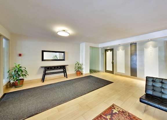 a living room with a rug and a black couch and a table