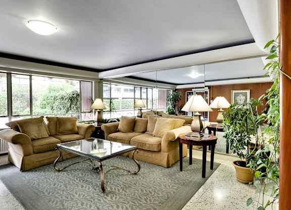 a living room with couches and a glass table
