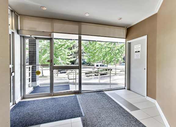 a lobby with glass doors and a view of a parking lot