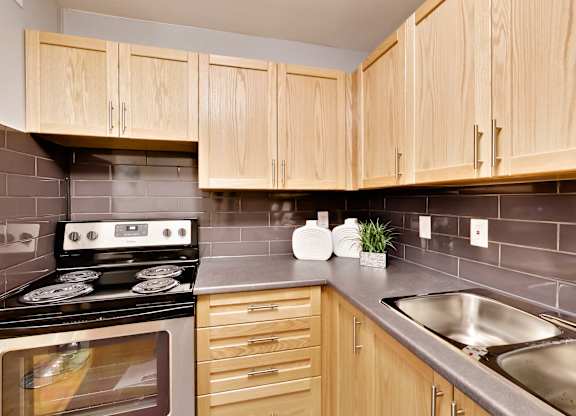 the kitchen has stainless steel appliances and wood cabinets