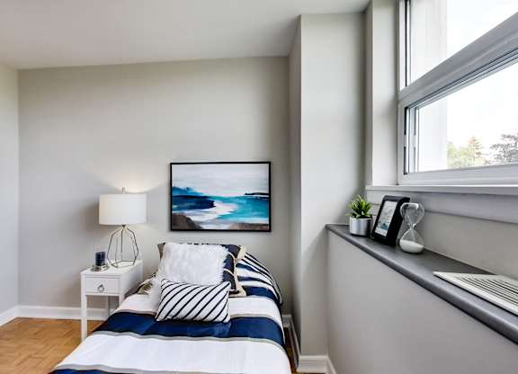 a small bedroom with a bed and a window