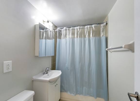 a bathroom with a blue shower curtain and a sink