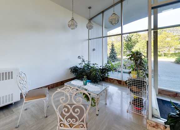 a living room with a table and chairs and a large window