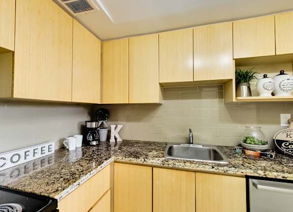 A kitchen with wooden cabinets and a granite countertop.