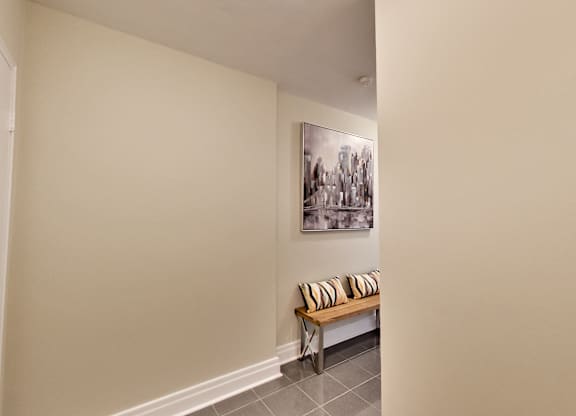 a hallway with a bench and a painting on the wall