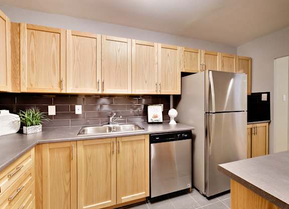 a kitchen with wooden cabinets and a stainless steel refrigerator