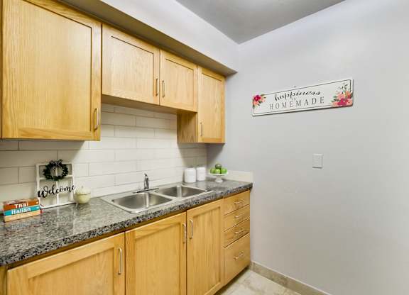 A kitchen with wooden cabinets and a sign that says