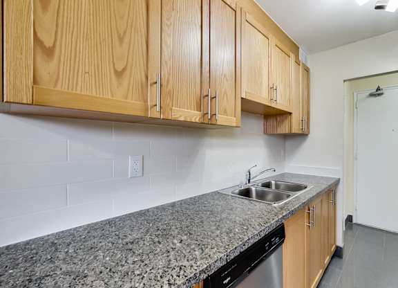 A kitchen with wooden cabinets and a granite countertop.