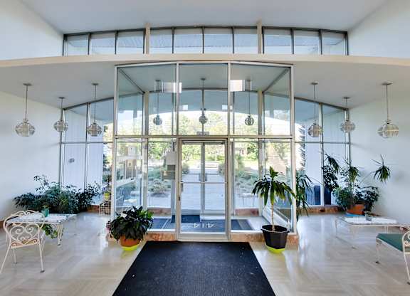 a living room with glass doors and potted plants