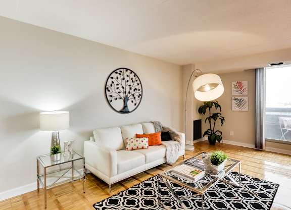a living room with a white couch and a glass coffee table and a large window