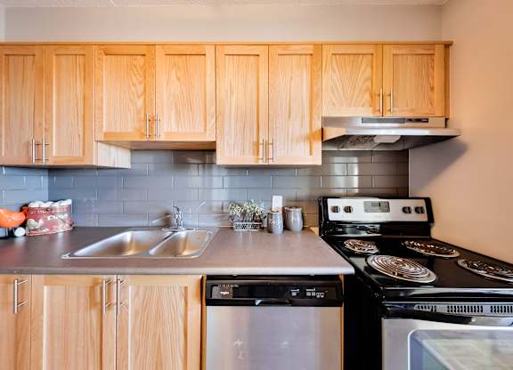 a kitchen with wooden cabinets and black appliances and a sink