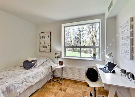 a bedroom with a bed and a desk and a window