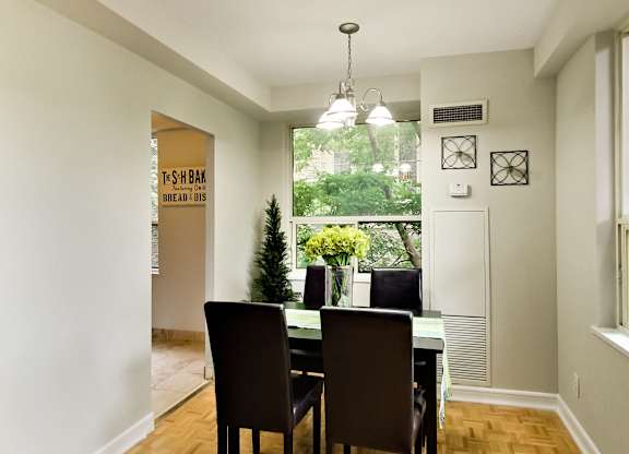 a dining room with a table and chairs and a window