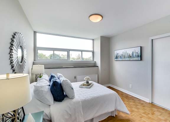 an empty bedroom with a bed and a window